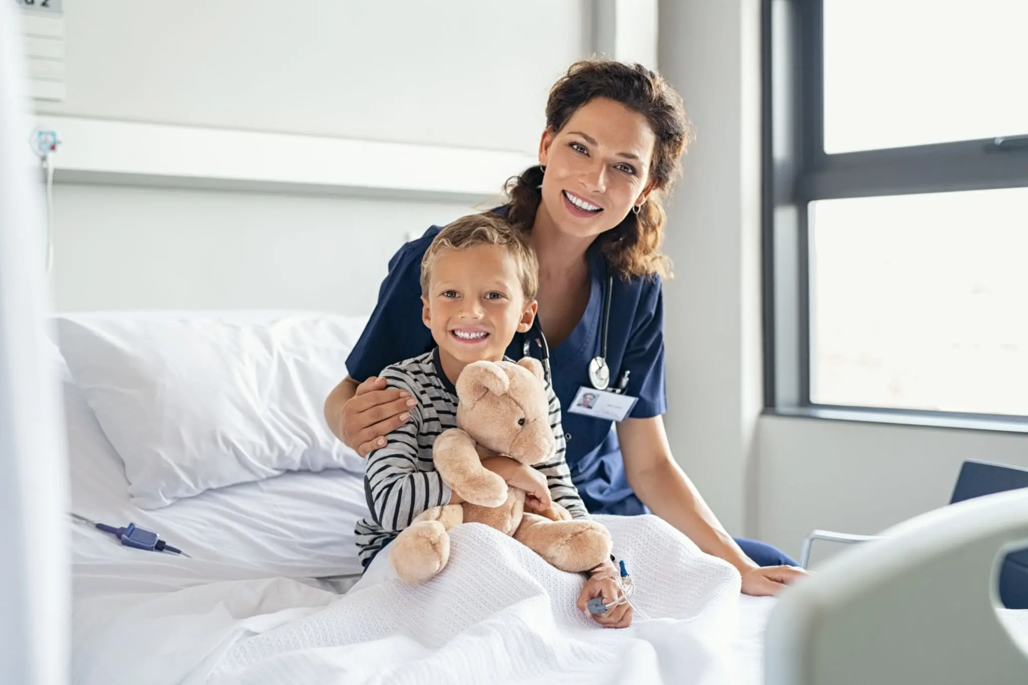 Child with nurse in hospital room.